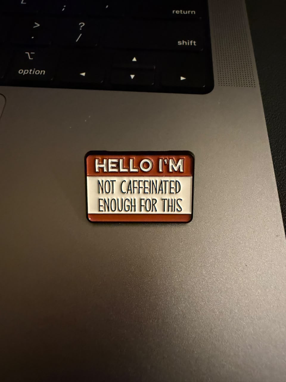 Enamel pin badge with text that reads Not Caffeinated Enough for this, a farewell gift by my colleague.