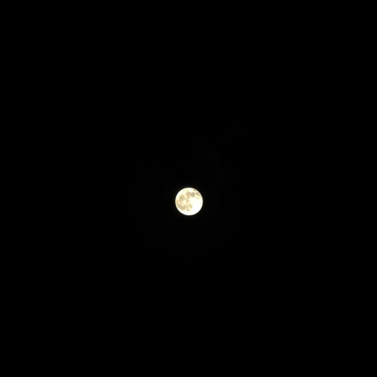 A nearly full Moon glowing against a completely dark night sky.
